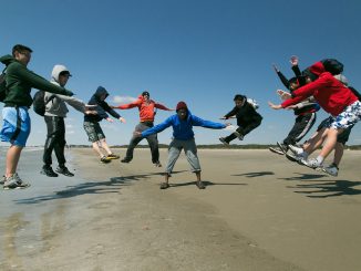 Teens jumping outdoors on the beach