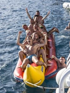 Lads having fun riding an inflatable banana