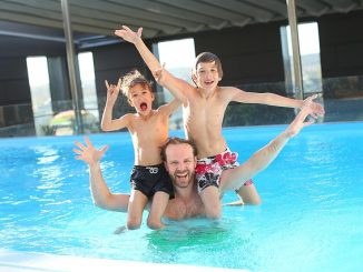 Dad and his boys having fun swimming