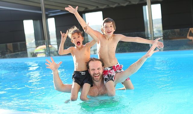 Dad and his boys having fun swimming