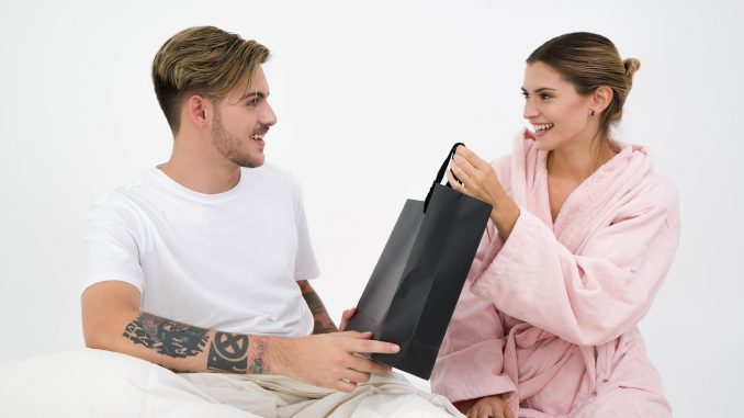 woman giving her boyfriend a gift present